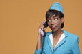 Cheerful young african stewardess talking on retro phone.