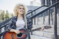 Cheerful young African woman standing and playing guitar with a smile on her face Royalty Free Stock Photo