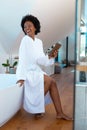 Cheerful young afro african american woman looking away in bathroom at home, copy space Royalty Free Stock Photo
