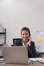 Cheerful young asian business woman talking on phone working in office. Happy positive Asian businesswoman company Royalty Free Stock Photo