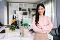 Cheerful young Asian businesswoman entrepreneur in casual smiling and looking at the camera while standing with her arms crossed. Royalty Free Stock Photo