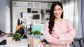 Cheerful young Asian businesswoman entrepreneur in casual smiling and looking at the camera while standing with her arms crossed. Royalty Free Stock Photo