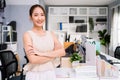 Cheerful young Asian businesswoman entrepreneur in casual smiling and looking at the camera while standing with her arms crossed. Royalty Free Stock Photo