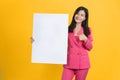 Cheerful Young Asian businesswoman is standing behind the white blank banner or empty copy space advertisement board on background Royalty Free Stock Photo