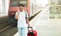 Cheerful young asian guy walking by station, talking on phone Royalty Free Stock Photo