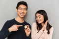 Cheerful young asian loving couple holding bitcoin. Royalty Free Stock Photo