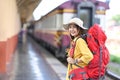 Young asian woman with backpack smiling to camera while standing in train station. Royalty Free Stock Photo