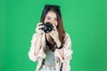 Cheerful young Asian woman with bag and digital camera ready enjoy travel over green isolated background Royalty Free Stock Photo