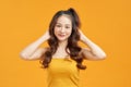 Cheerful young asian woman girl in yellow crop top posing isolated on yellow background