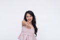 A cheerful young asian woman makes a heart finger gesture. Happy with her life or being playfully romantic. on a white