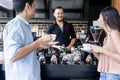 Cheerful young bartender cleaning the coffee maker while talking