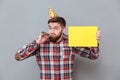 Cheerful young bearded birthday man holding copyspace board