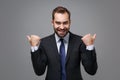 Cheerful young bearded business man in classic black suit shirt tie posing isolated on grey background in studio Royalty Free Stock Photo