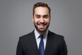 Cheerful young bearded business man in classic black suit shirt tie posing isolated on grey background studio portrait Royalty Free Stock Photo