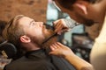 Cheerful young bearded man at hair salon