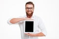 Cheerful young bearded man showing display of tablet computer. Royalty Free Stock Photo