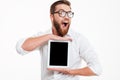 Cheerful young bearded man showing display of tablet computer. Royalty Free Stock Photo