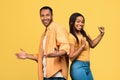 Cheerful young black couple dancing, celebrating success together on yellow studio background Royalty Free Stock Photo