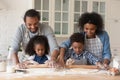 Cheerful young Black couple and little kids baking pie together Royalty Free Stock Photo