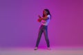 Cheerful Young Black Female Dancing in Neon Light Over Purple Background Royalty Free Stock Photo