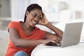 Cheerful Young Black Female Sitting At Desk And Using Laptop At Home Royalty Free Stock Photo