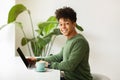 Cheerful young black guy freelancer working from cozy cafe Royalty Free Stock Photo