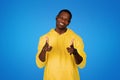 Cheerful young black man point fingers at camera, motivating for work, study