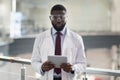 Cheerful young black medical scientist using digital tablet Royalty Free Stock Photo