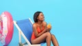 Cheerful black woman relaxing in lounge chair with fruit cocktail, laughing and enjoying her tropical summer vacation Royalty Free Stock Photo