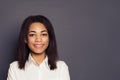 Cheerful young black woman smiling on gray background, face close up