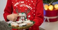 a young boy in a christmas shirt holding a tray full of cookies