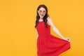 Cheerful young brunette woman girl in red summer dress, eyeglasses posing isolated on yellow wall background studio Royalty Free Stock Photo