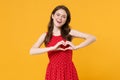 Cheerful young brunette woman girl in red summer dress posing isolated on yellow wall background studio. People Royalty Free Stock Photo