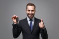 Cheerful young business man in classic black suit shirt tie posing isolated on grey wall background. Achievement career Royalty Free Stock Photo