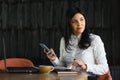 Cheerful young business woman standing in modern office talking on her mobile phone. Beautiful female model using cell phone Royalty Free Stock Photo