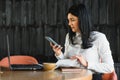 Cheerful young business woman standing in modern office talking on her mobile phone. Beautiful female model using cell phone Royalty Free Stock Photo