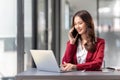 Cheerful young business woman talking on phone working in modern office. Happy positive Asian businesswoman company Royalty Free Stock Photo