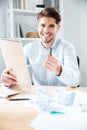 Cheerful young businessman giving notepad and pen to you Royalty Free Stock Photo