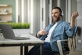 Cheerful young businessman having fun at workplace in office, playing virtual guitar Royalty Free Stock Photo