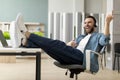 Cheerful young businessman in headphones playing virtual guitar during break in office Royalty Free Stock Photo