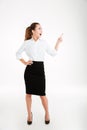 Cheerful young businesswoman pointing finger away Royalty Free Stock Photo