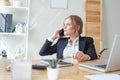 Cheerful young businesswoman sitting at her workplace Royalty Free Stock Photo