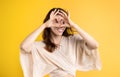 Cheerful young caucasian woman in casual looking through heart sign with hands, has fun