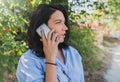 Cheerful young Caucasian woman wearing blue shirt talking on mobile phone about new project. People, lifestyle and business Royalty Free Stock Photo