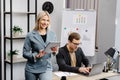 Cheerful young corporate lawyers in formal wear editing text of new contract using laptop sitting at table with laptop in modern Royalty Free Stock Photo