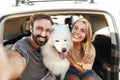 Cheerful young couple at the beach, playing with their dog Royalty Free Stock Photo