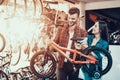 Cheerful Young Couple Chooses Kids Bicycle in Store