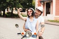 Cheerful young couple in crash helmets making selfie on smartphone Royalty Free Stock Photo