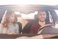 Cheerful young couple has auto journey, family has pleasant conversation while travelling by car, happy young male and female has Royalty Free Stock Photo