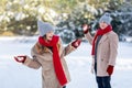 Cheerful young couple having snowball fight outdoors Royalty Free Stock Photo